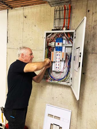 Romeo of Champion Electrical Services working on a switchboard